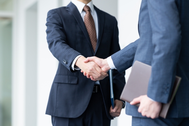 握手するスーツの男性