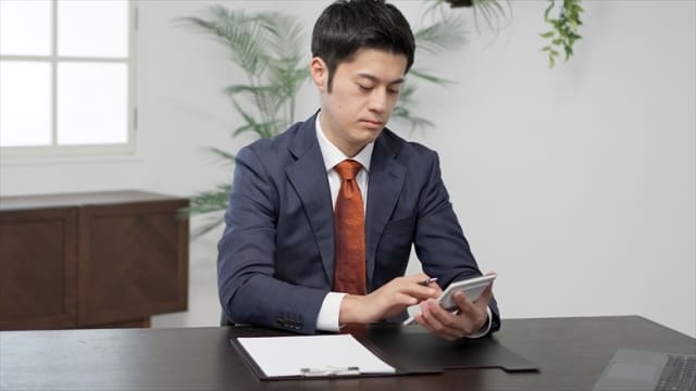 電卓を打つ男性