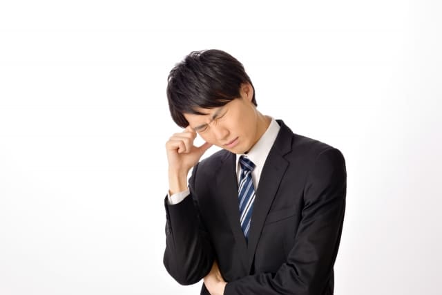 悩むスーツの男性