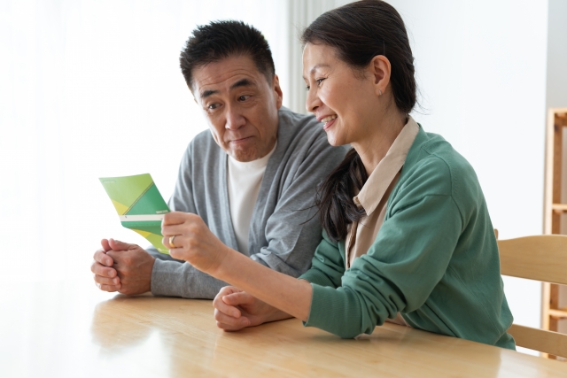 通帳を見る夫婦