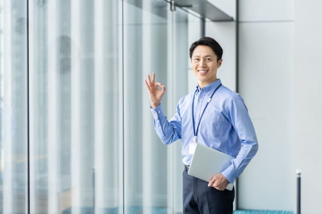 OKサインを出すスーツの男性