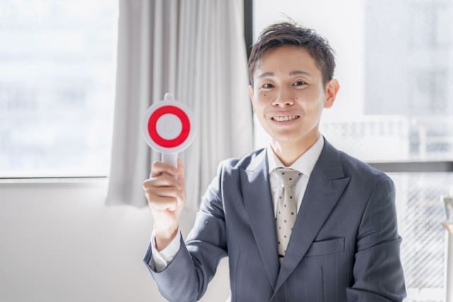 丸サインを出すスーツの男性